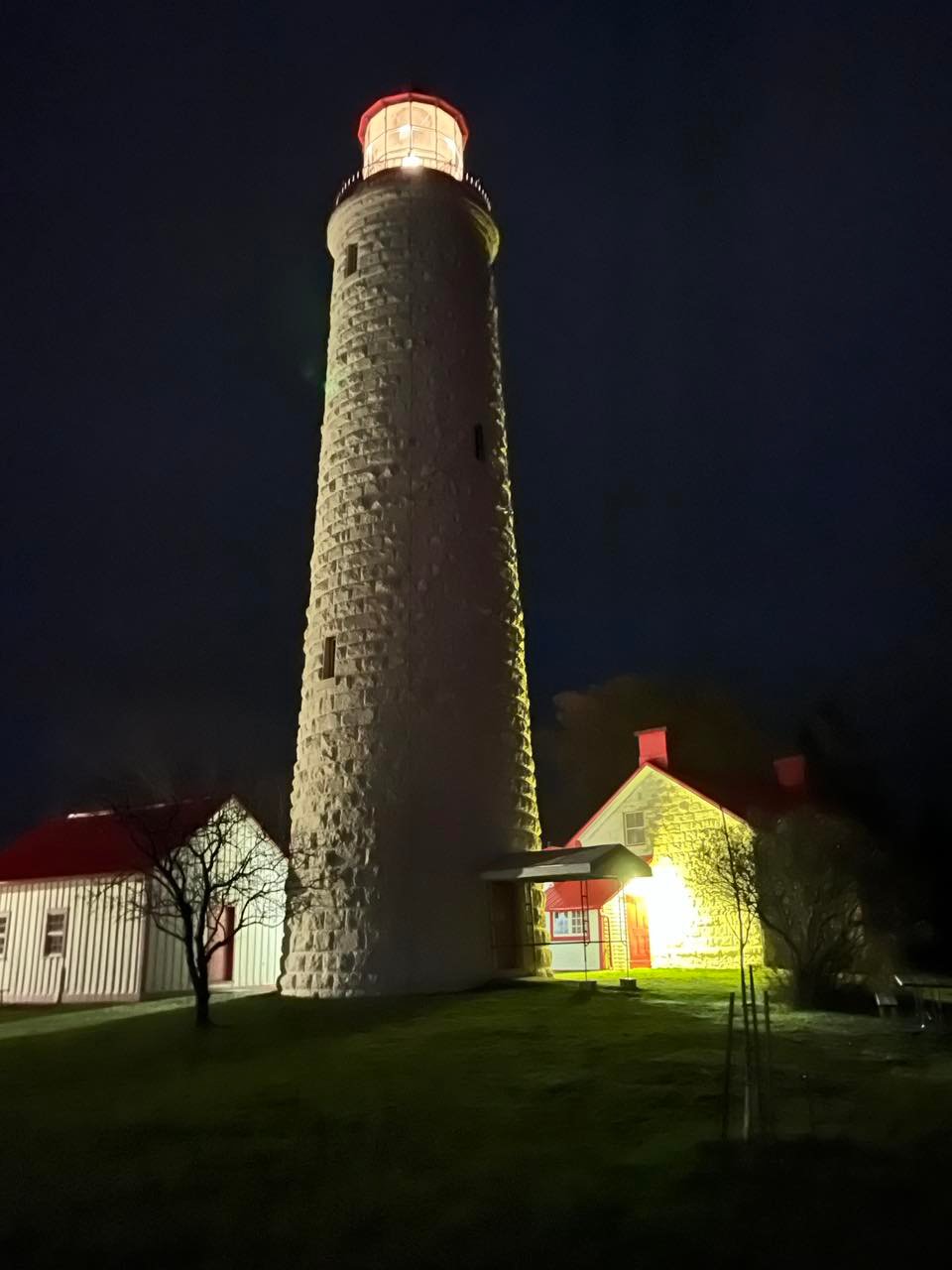 The beautiful lighthouse in Point Clarke lights up the sky at night.