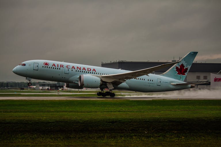 An Air Canada airplane touching down on a runway flying into Canada