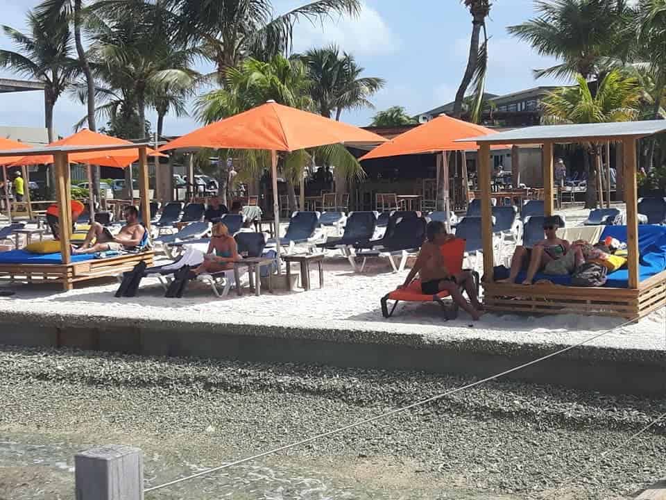 Relaxing beachside at a resort in Bonaire. There are lots of chairs and beach beds for guests and visitors