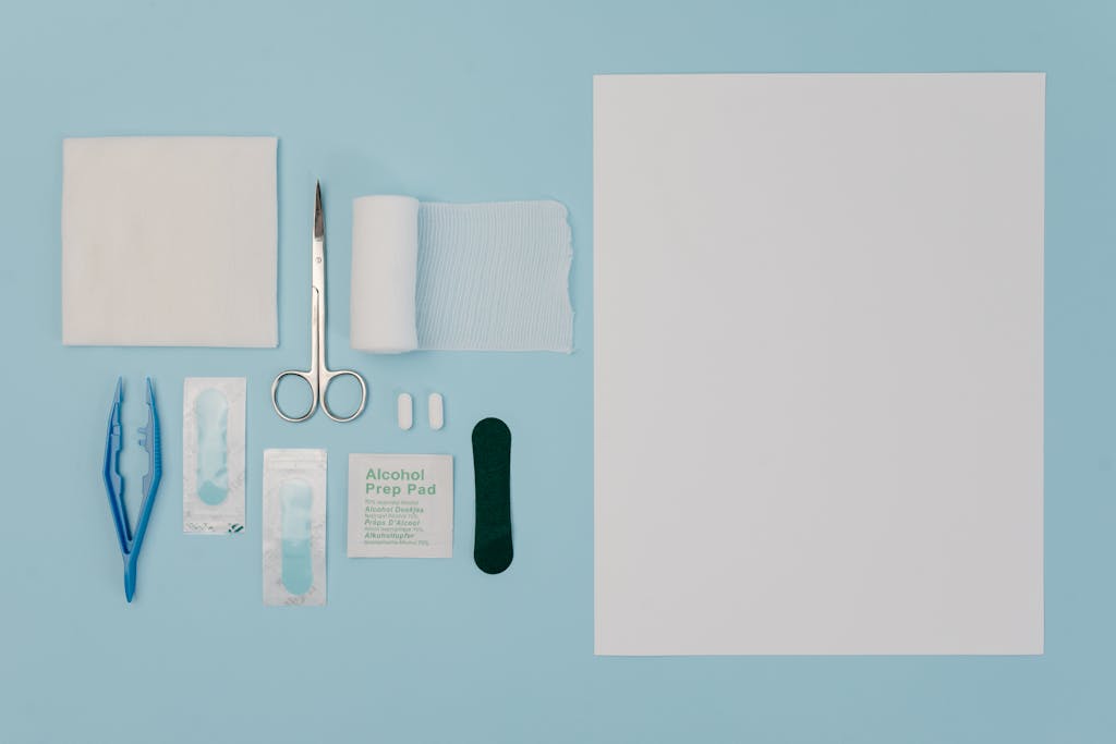 Organized display of medical tools and supplies including gauze, scissors, and bandages on a blue surface.